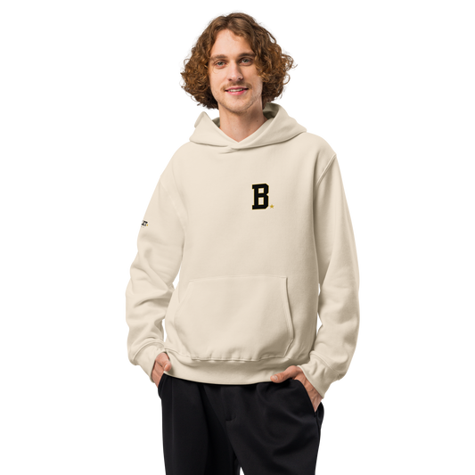 Athlete wearing bone Field Hoodie with minimalist varsity B chest logo