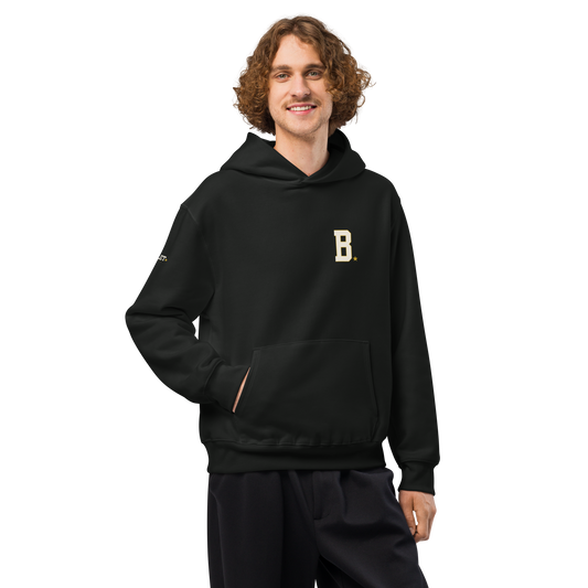 Athlete wearing black Field Hoodie with minimalist varsity B chest logo